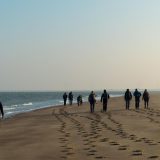 Wandelsporen op het Zeeuwse strand met in de verte de Oosterscheldekering (Wouter de Vries)